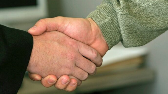 a close up of two people shaking hands
