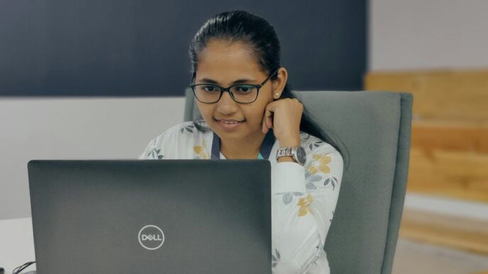 a woman sitting in front of a laptop computer
