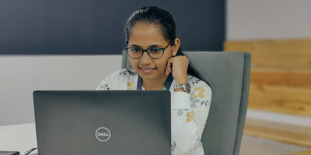 a woman sitting in front of a laptop computer