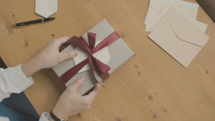 a person opening a gift box with a red ribbon
