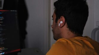 A man sitting in front of a computer monitor