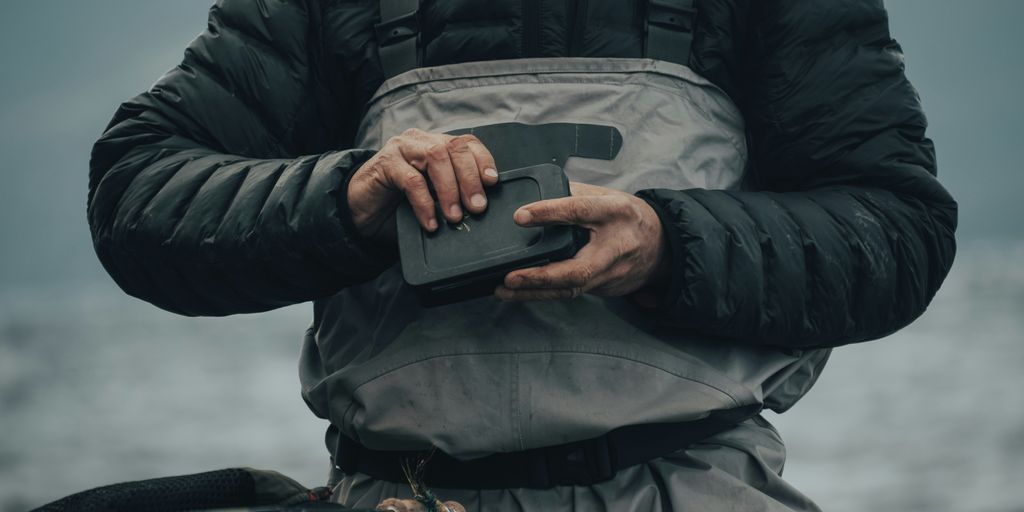 person in black jacket holding black smartphone