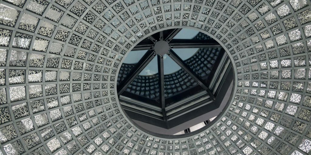 low-angle photo of grey and white concrete dome ceiling