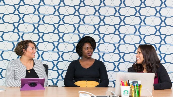 three women sitting on chairs front of table