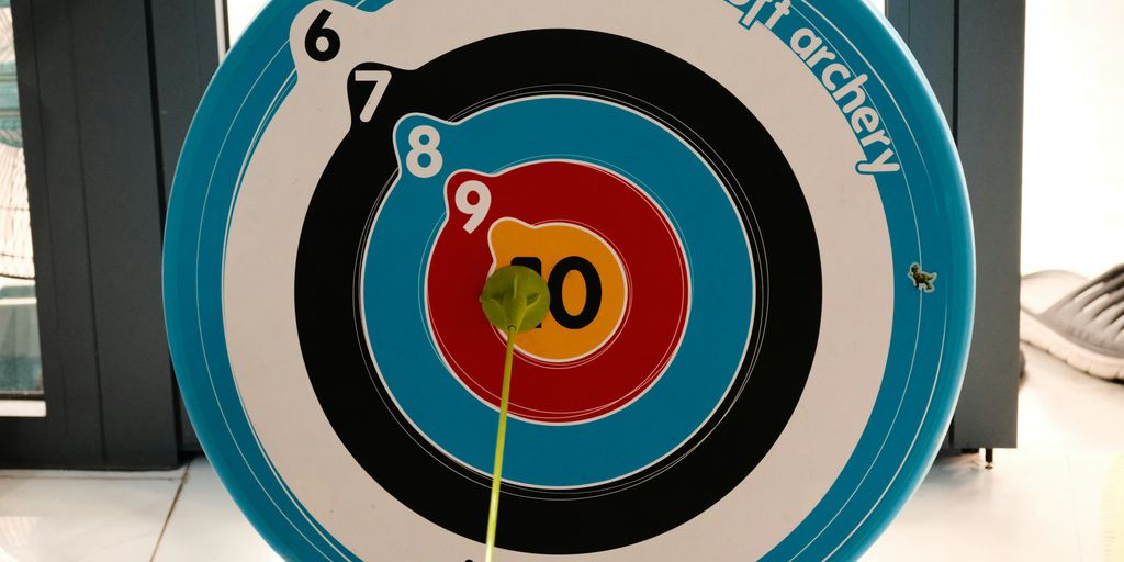 An arrow hits the bullseye on a target.