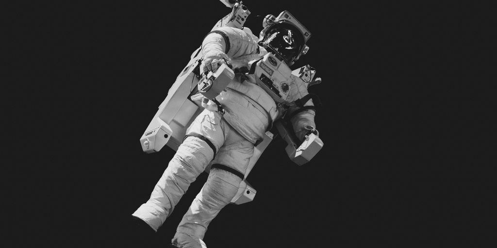 astronaut in white suit in grayscale photography