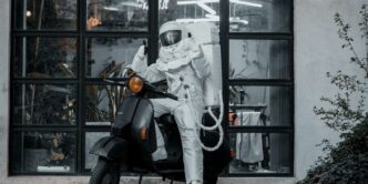 Astronaut rides a scooter in front of a window.