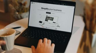 A person sitting at a table using a laptop computer