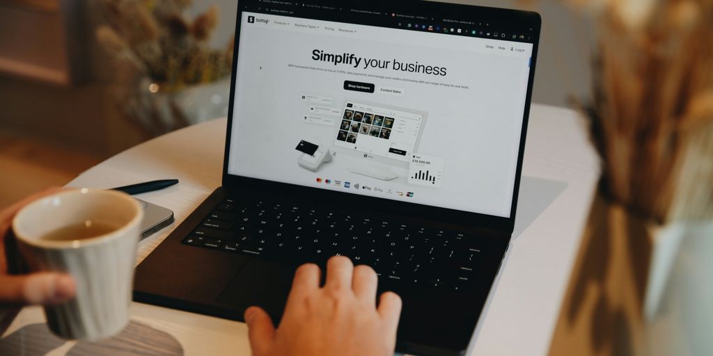 A person sitting at a table using a laptop computer