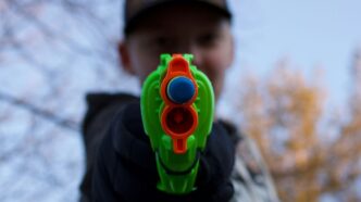 man in black and white hoodie with green and yellow round plastic toy
