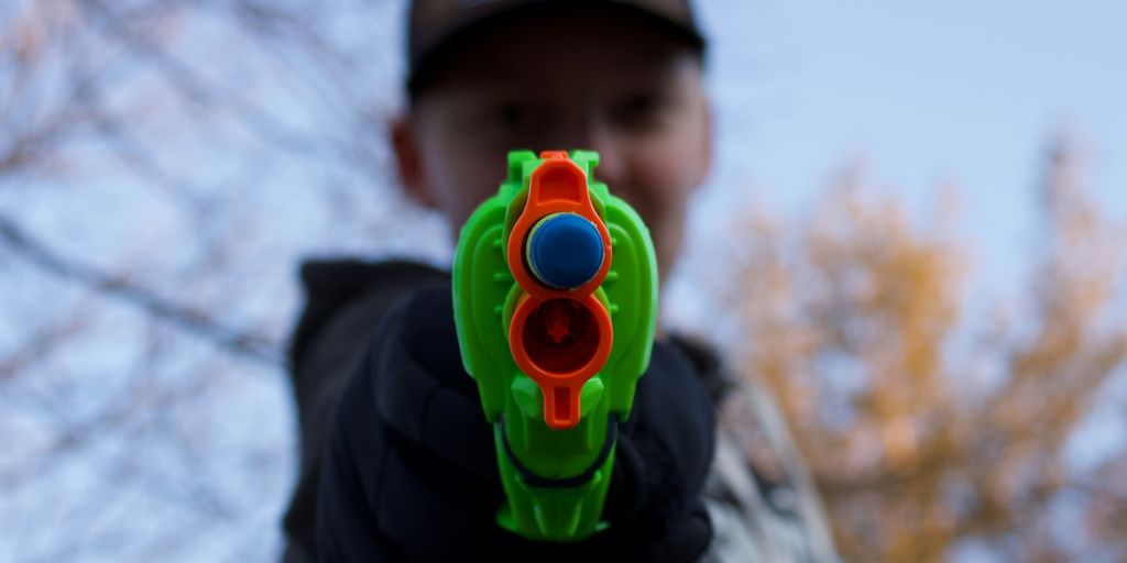 man in black and white hoodie with green and yellow round plastic toy