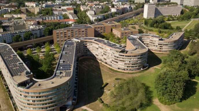 an aerial view of a city with a curved building