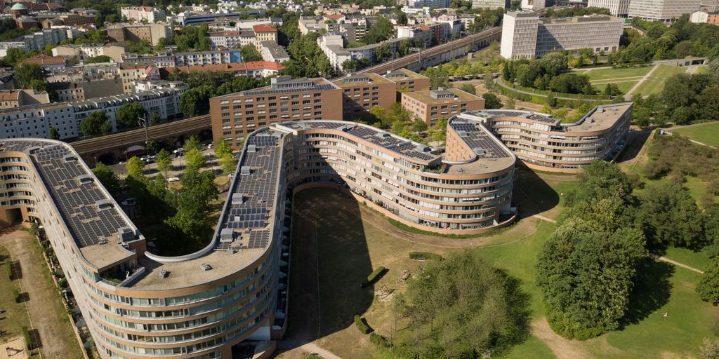 an aerial view of a city with a curved building
