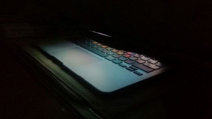 a laptop computer lit up in the dark