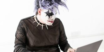 a person in a mask using a laptop