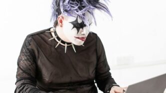 a person in a mask using a laptop