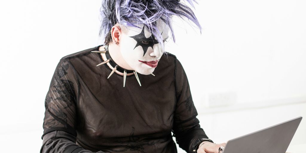 a person in a mask using a laptop