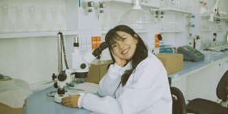 woman in white laboratory gown holding black microphone