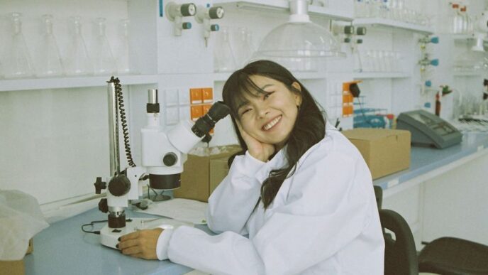 woman in white laboratory gown holding black microphone