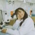 woman in white laboratory gown holding black microphone