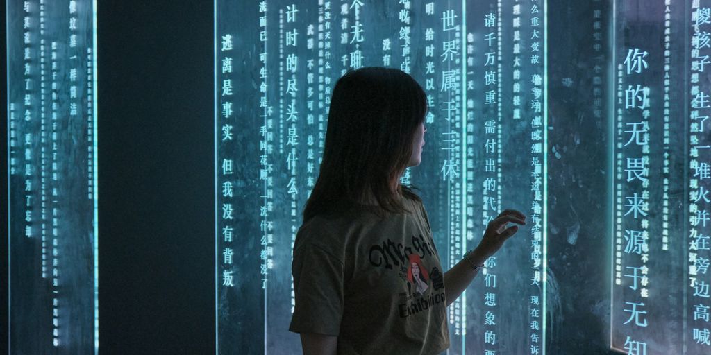 woman in gray crew neck t-shirt standing in front of blue and white string lights
