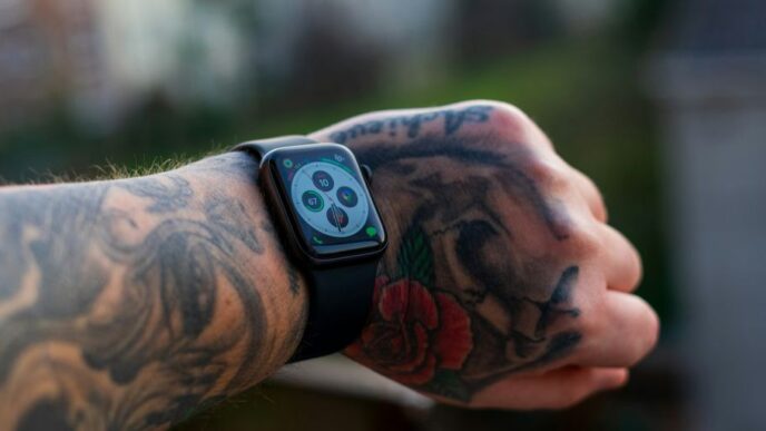 a man with a tattoo on his arm holding a cell phone