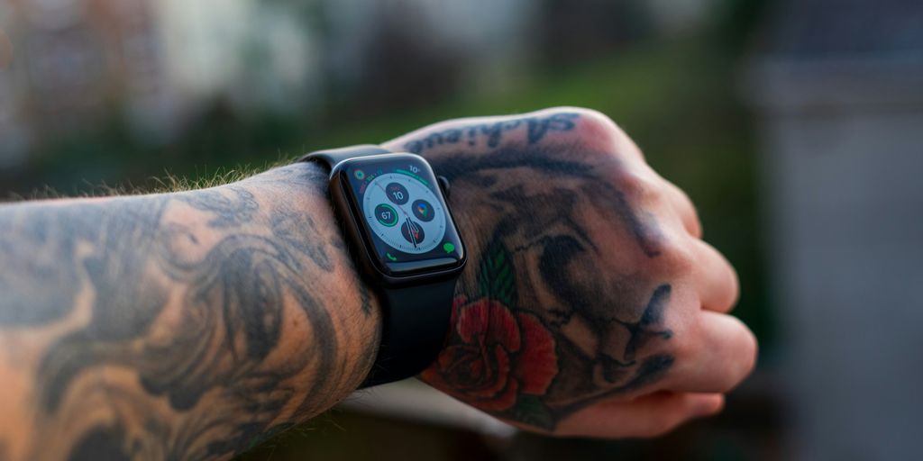 a man with a tattoo on his arm holding a cell phone
