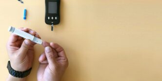 a person holding a cigarette next to an electronic device