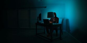 man siting facing laptop