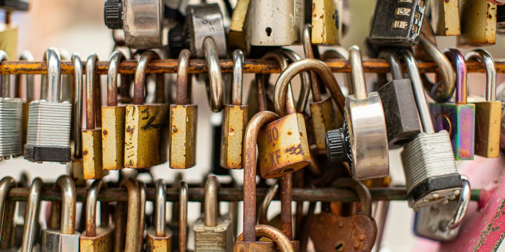 a bunch of padlocks are hanging on a wall