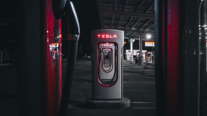 a gas pump in a parking lot at night