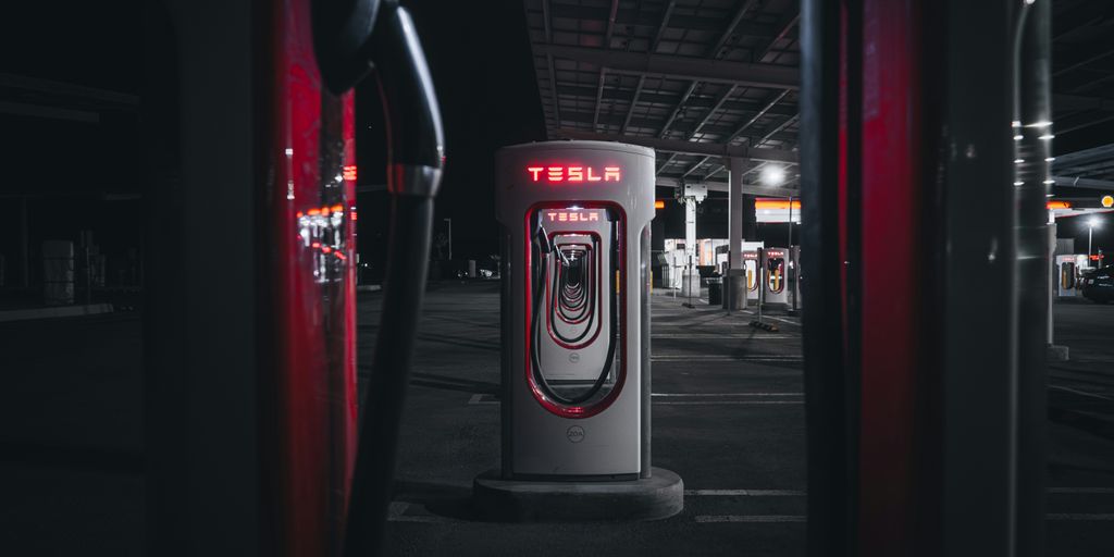 a gas pump in a parking lot at night