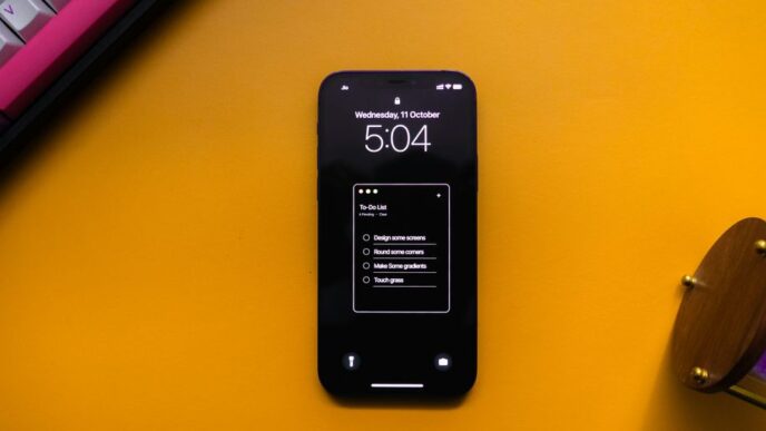 a cell phone sitting on top of a desk next to a keyboard