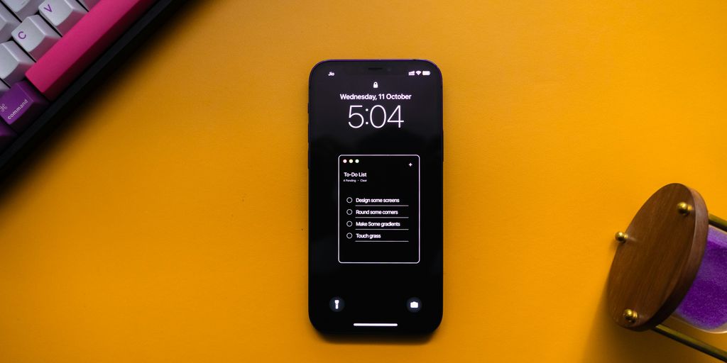 a cell phone sitting on top of a desk next to a keyboard