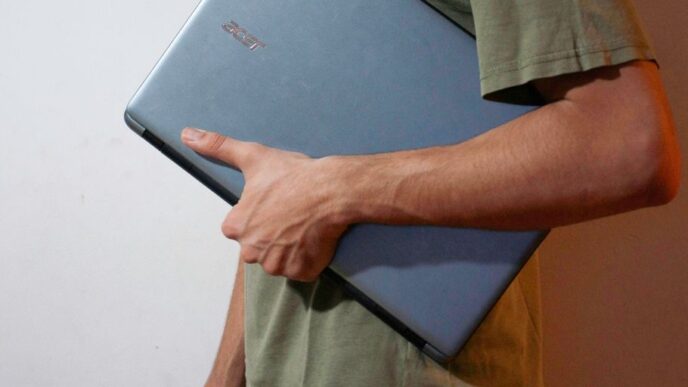 man in green button up shirt holding black tablet computer