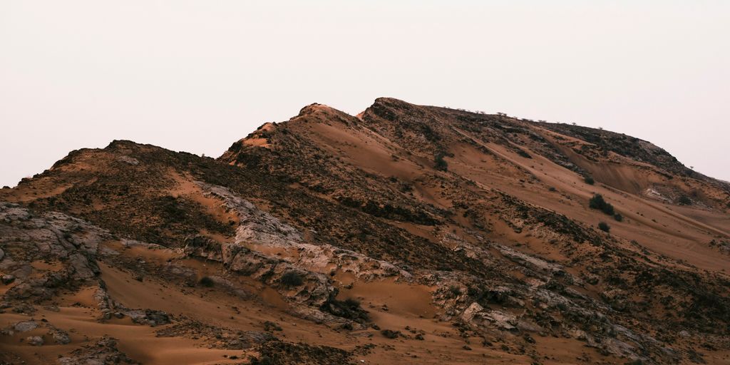 brown and white mountains under white sky during daytime