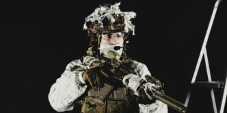 a man dressed in camouflage holding a rifle