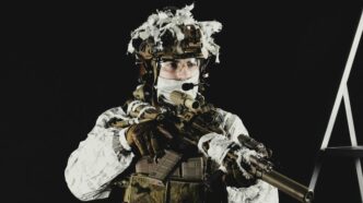 a man dressed in camouflage holding a rifle
