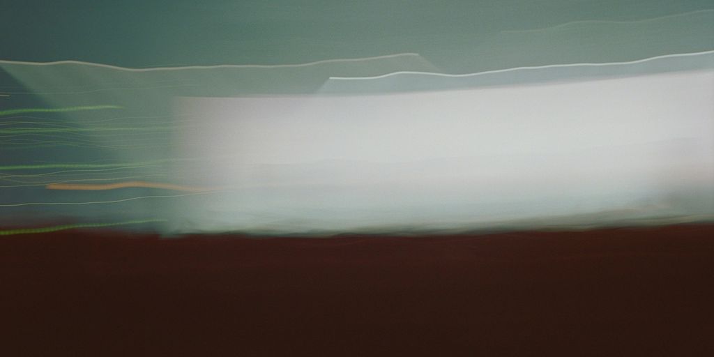 a blurry photo of a field with a sky in the background