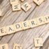 scrabble tiles spelling out the word leadership on a wooden surface