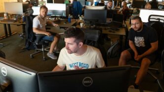 a group of men working on computers in an office