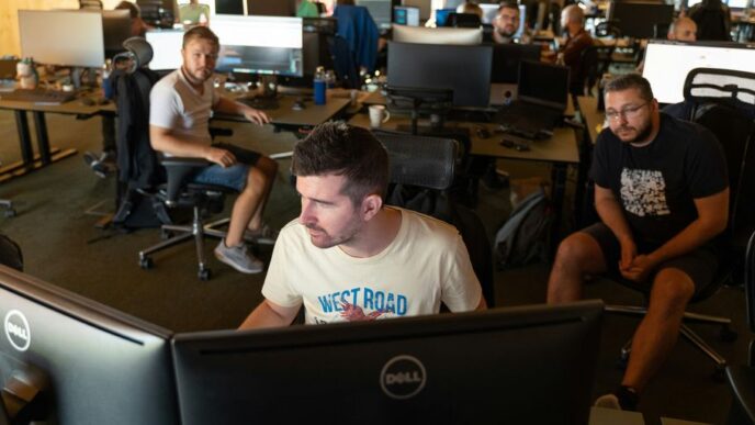 a group of men working on computers in an office
