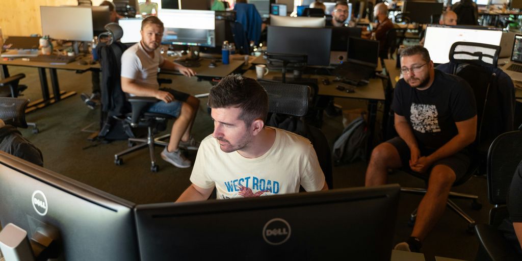 a group of men working on computers in an office