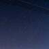 a night sky with stars and a line of power lines