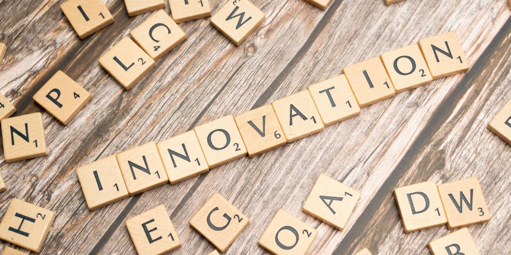 scrabble tiles spelling the word innovation on a wooden surface