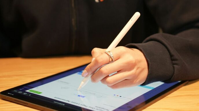 a person writing on a tablet with a pen