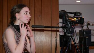 a woman standing next to a camera
