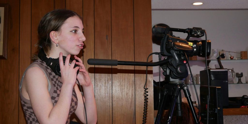 a woman standing next to a camera