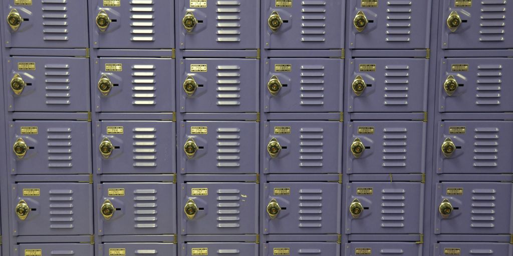 a wall of purple lockers with yellow tags on them