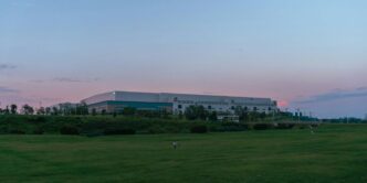 a large building sitting on top of a lush green field